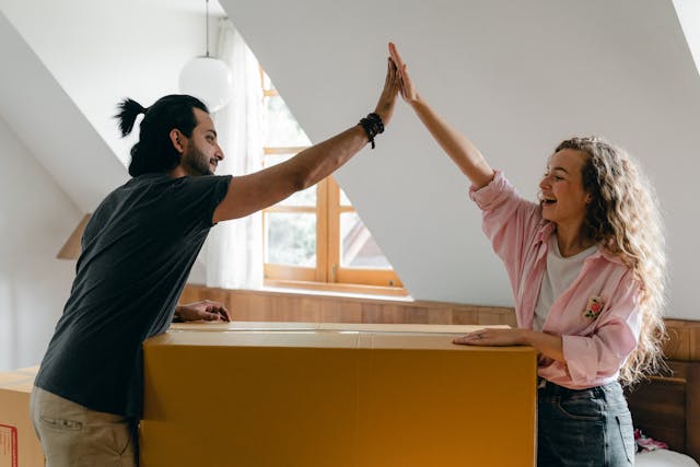 two people high-fiving over a moving box